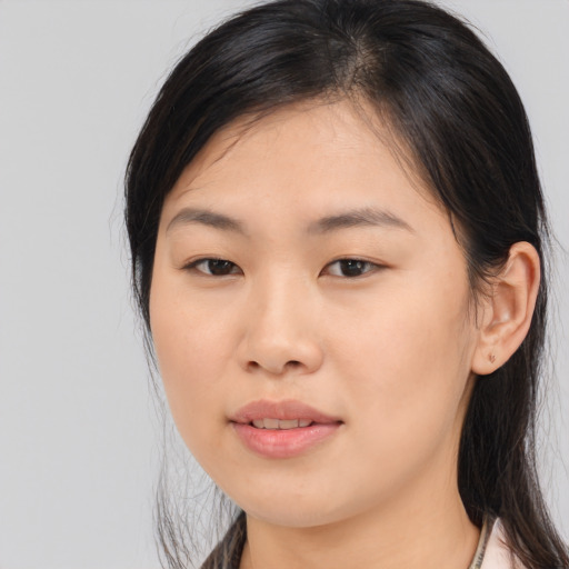 Joyful asian young-adult female with long  brown hair and brown eyes