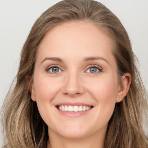 Joyful white young-adult female with long  brown hair and blue eyes