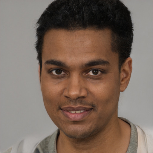 Joyful black young-adult male with short  black hair and brown eyes