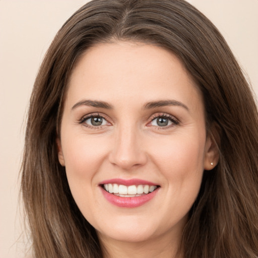 Joyful white young-adult female with long  brown hair and brown eyes