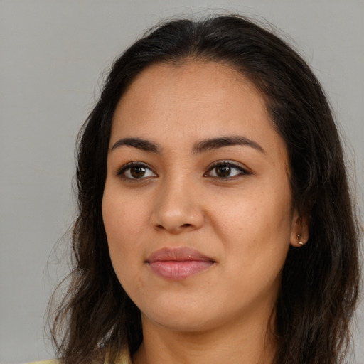 Joyful latino young-adult female with long  brown hair and brown eyes