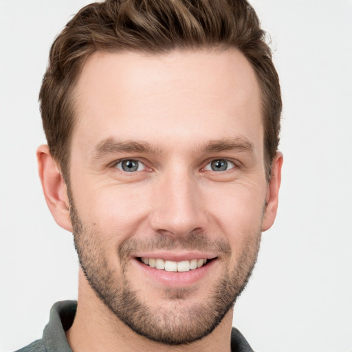 Joyful white young-adult male with short  brown hair and grey eyes