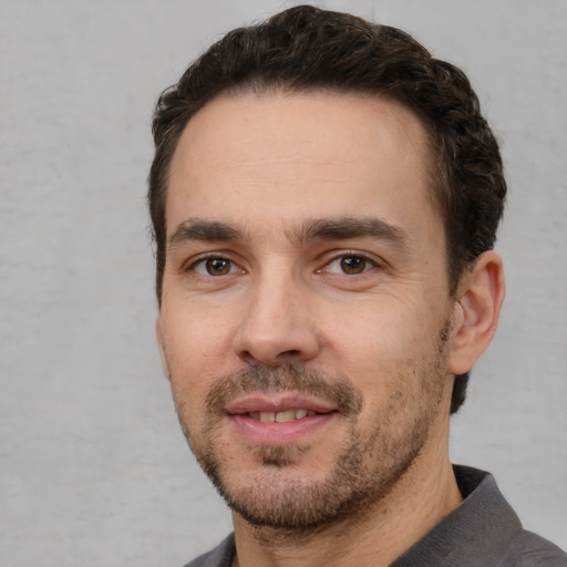 Joyful white young-adult male with short  black hair and brown eyes