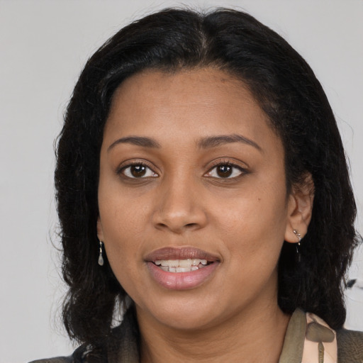 Joyful black young-adult female with medium  brown hair and brown eyes