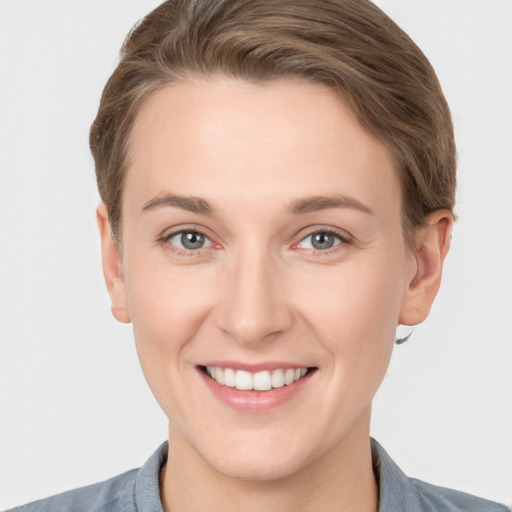 Joyful white young-adult female with short  brown hair and grey eyes