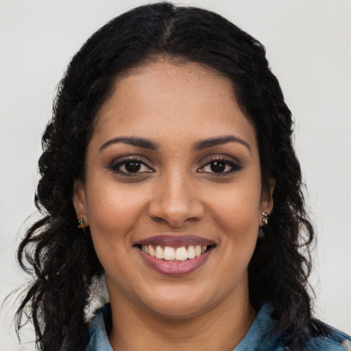 Joyful black young-adult female with long  black hair and brown eyes