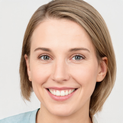 Joyful white young-adult female with medium  brown hair and blue eyes