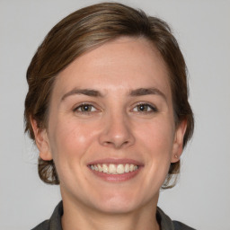 Joyful white adult female with medium  brown hair and grey eyes