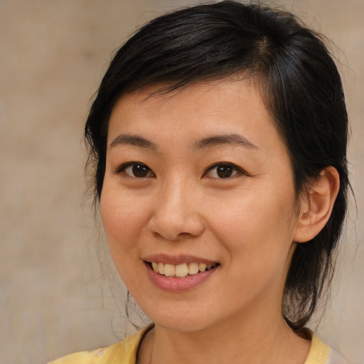 Joyful asian young-adult female with medium  brown hair and brown eyes