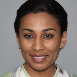 Joyful latino young-adult female with short  black hair and brown eyes