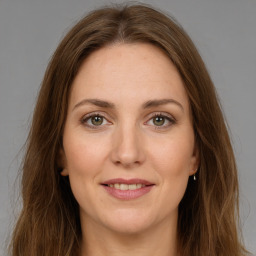 Joyful white young-adult female with long  brown hair and green eyes