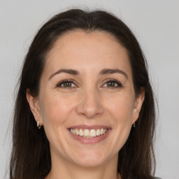 Joyful white adult female with long  brown hair and brown eyes