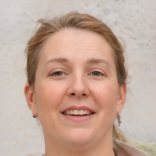 Joyful white adult female with short  brown hair and blue eyes