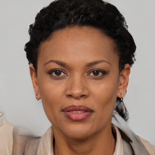 Joyful black young-adult female with short  black hair and brown eyes