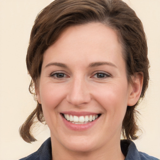 Joyful white young-adult female with medium  brown hair and grey eyes