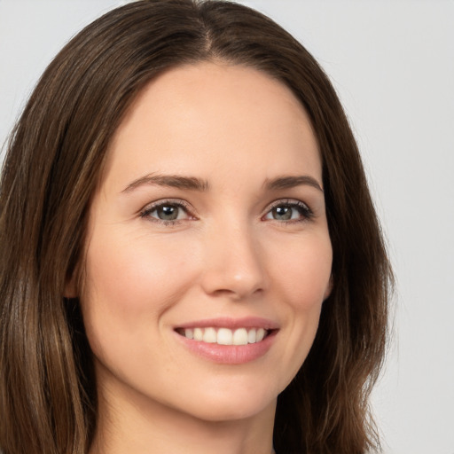 Joyful white young-adult female with long  brown hair and brown eyes