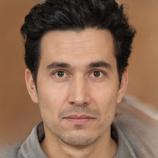 Joyful white adult male with short  black hair and brown eyes