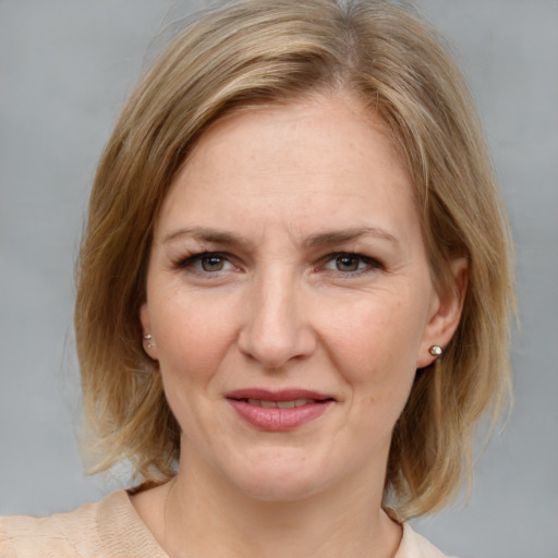 Joyful white adult female with medium  brown hair and grey eyes