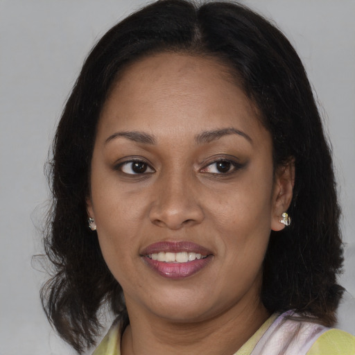 Joyful black adult female with medium  brown hair and brown eyes
