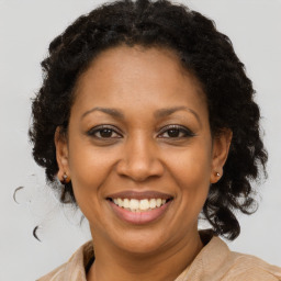 Joyful black adult female with medium  brown hair and brown eyes