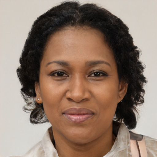 Joyful black adult female with medium  brown hair and brown eyes
