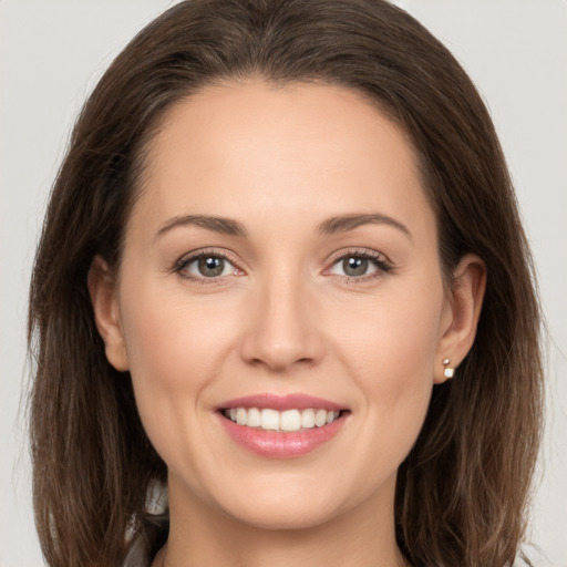 Joyful white young-adult female with long  brown hair and grey eyes