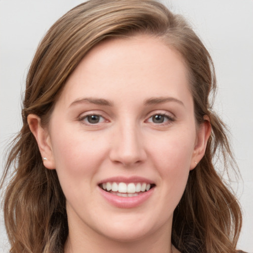 Joyful white young-adult female with long  brown hair and blue eyes