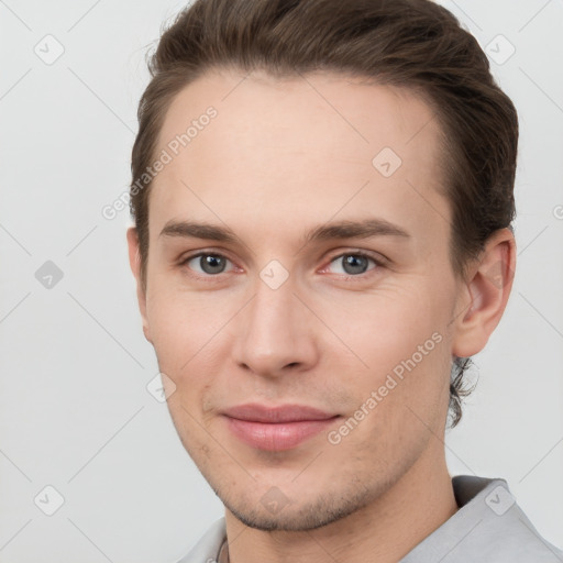 Joyful white young-adult male with short  brown hair and grey eyes