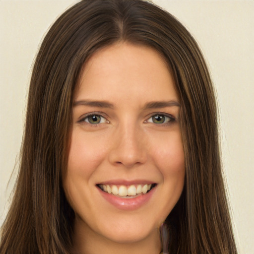 Joyful white young-adult female with long  brown hair and green eyes