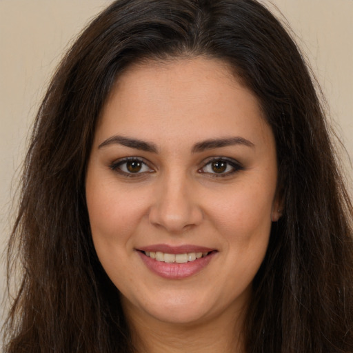 Joyful white young-adult female with long  brown hair and brown eyes