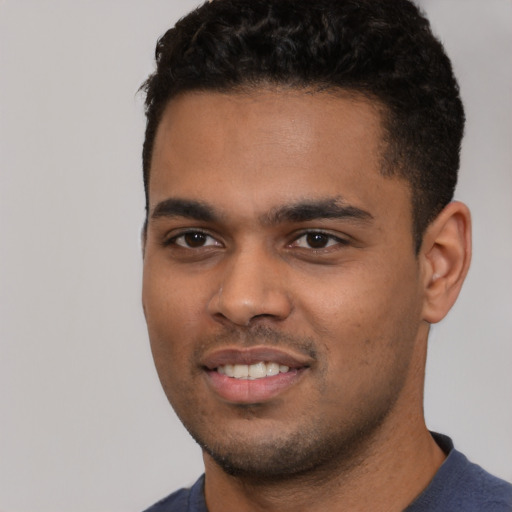 Joyful black young-adult male with short  black hair and brown eyes