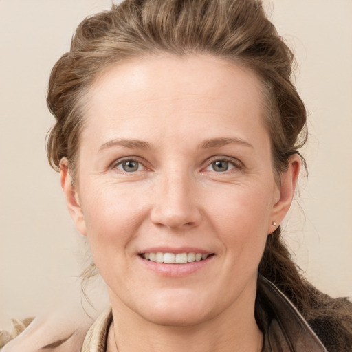 Joyful white adult female with long  brown hair and grey eyes