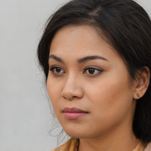 Joyful asian young-adult female with long  brown hair and brown eyes