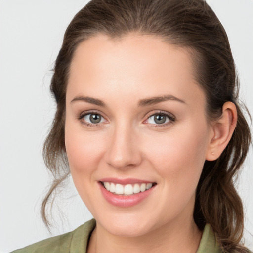 Joyful white young-adult female with medium  brown hair and grey eyes