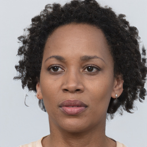 Joyful black adult female with short  brown hair and brown eyes