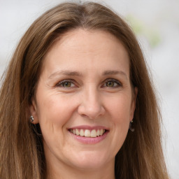 Joyful white adult female with long  brown hair and grey eyes