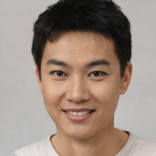 Joyful asian young-adult male with short  brown hair and brown eyes
