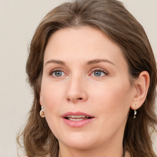 Joyful white young-adult female with long  brown hair and blue eyes