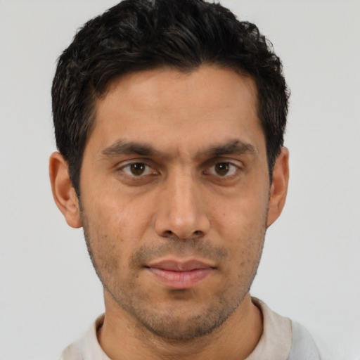 Joyful latino young-adult male with short  brown hair and brown eyes