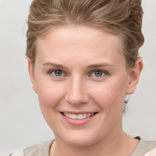 Joyful white young-adult female with short  brown hair and grey eyes