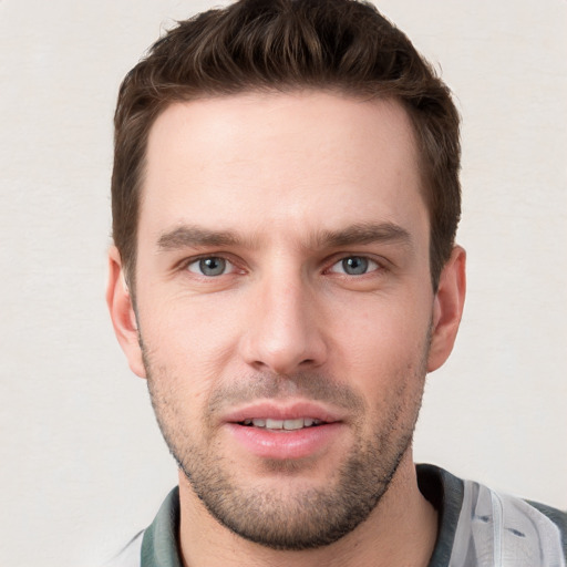 Joyful white young-adult male with short  brown hair and grey eyes