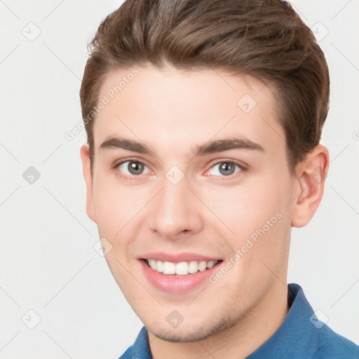 Joyful white young-adult male with short  brown hair and grey eyes