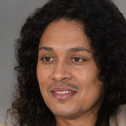 Joyful black adult female with long  black hair and brown eyes