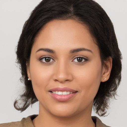 Joyful latino young-adult female with medium  brown hair and brown eyes