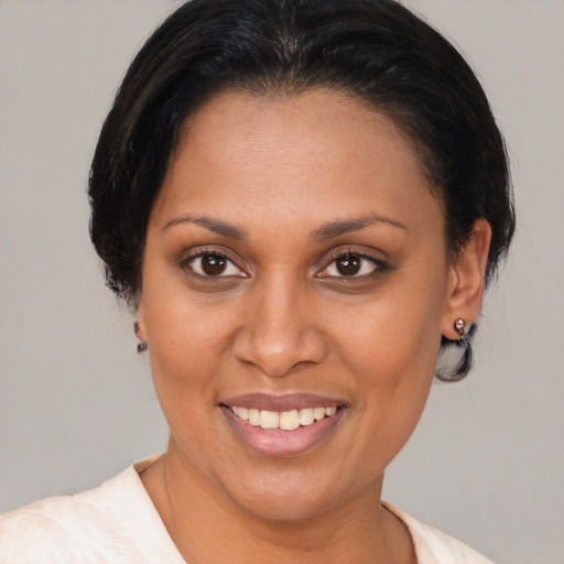 Joyful latino adult female with medium  brown hair and brown eyes