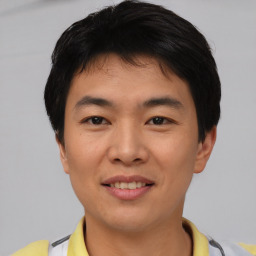 Joyful asian young-adult male with short  black hair and brown eyes