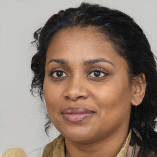 Joyful black adult female with long  brown hair and brown eyes