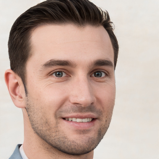 Joyful white young-adult male with short  brown hair and grey eyes