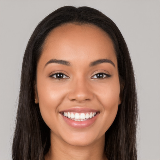 Joyful latino young-adult female with long  brown hair and brown eyes