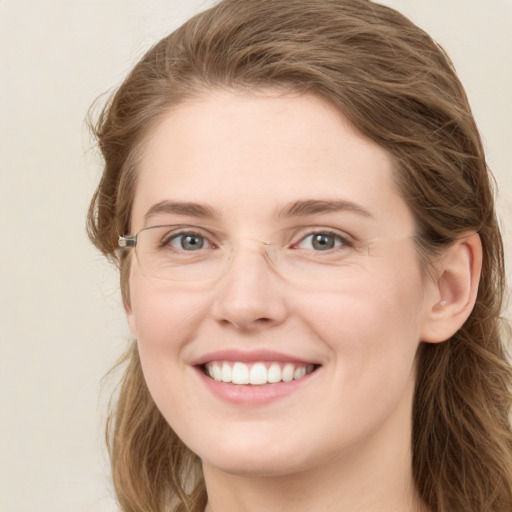 Joyful white young-adult female with long  brown hair and green eyes